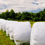 Countryside,Field,With,Hay,Bales,Wrapped,In,Plastic,On,Sunny